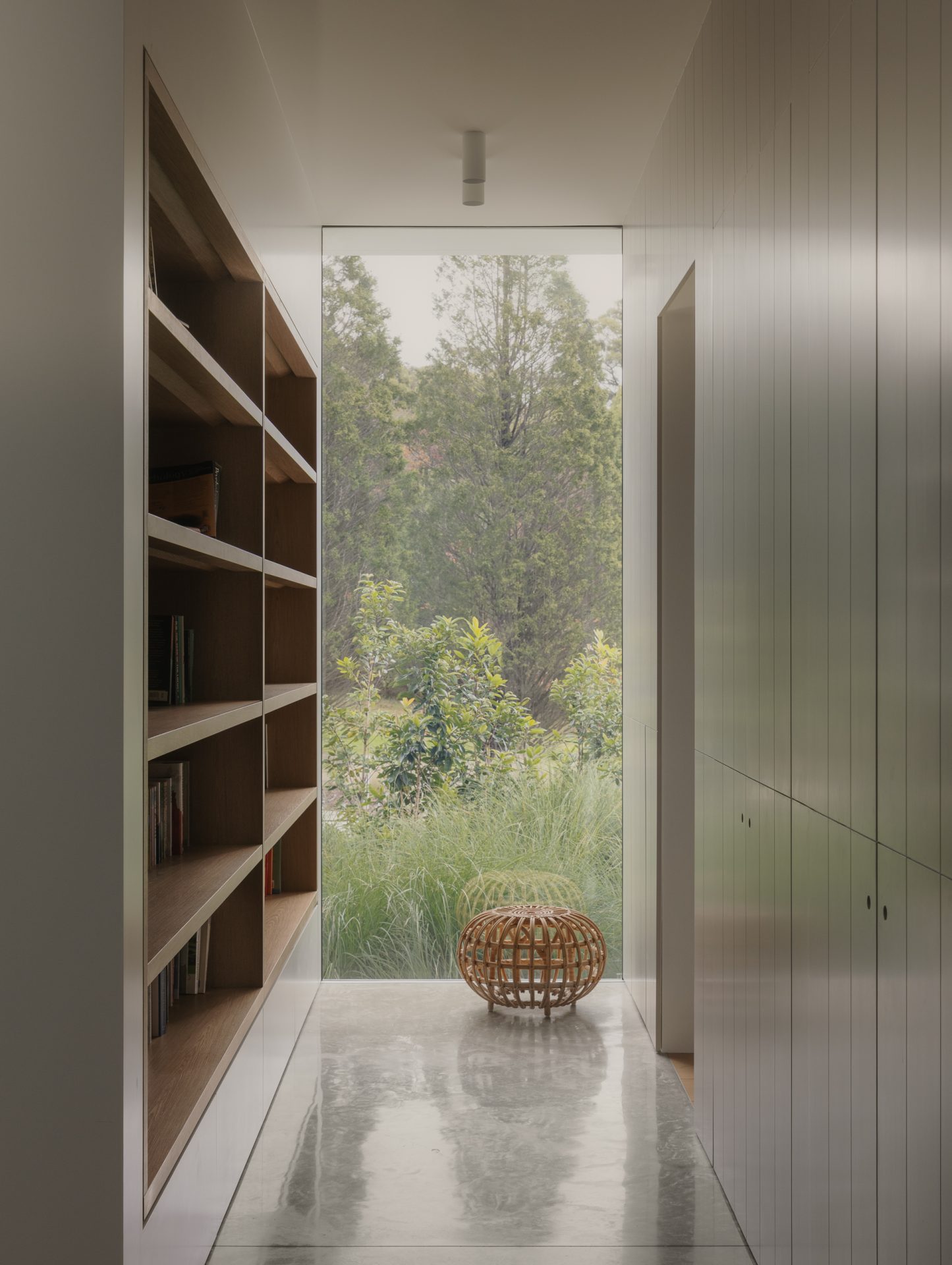 Built-in bookshelf hallway opening to the courtyard at Melody House